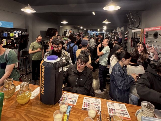 La tienda de Probikes llena de gente en la charla de nutrición, con las bebidas de Nutremax en la mesa